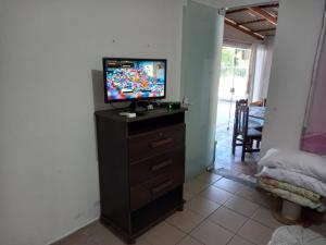 a television sitting on top of a dresser in a room at Casa temporada próximo à parque in Penha