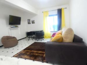 a living room with a couch and a television at Apartamento Marisol Confort in Aroeira