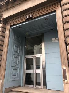 a front door of a building with a sign on it at Comfy Two Bedroom Apartment Right In The City Centre in Glasgow