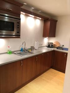 a kitchen with a sink and a microwave at Comfy Two Bedroom Apartment Right In The City Centre in Glasgow