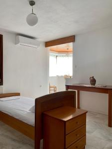 um quarto com uma cama, uma mesa e uma janela em Κατοικία σε Συγκρότημα στην Ουρανούπολη em Ouranoupoli