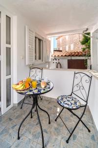 un tavolo con un cesto di frutta in cucina di Apartmani P&S a Supetar (San Pietro di Brazza)