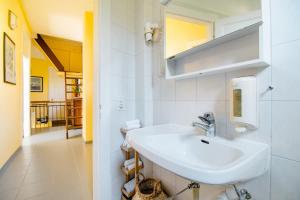 a white bathroom with a sink and a hallway at Pensione Solaria in Locarno