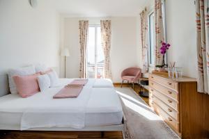 a bedroom with a large white bed and a dresser at Pensione Solaria in Locarno
