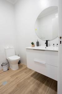 a white bathroom with a toilet and a mirror at MY DREAM in Alcains