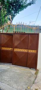 brązowe drzwi garażowe z ogrodzeniem na górze w obiekcie Dibra Home near City Center of Shkodra w Szkodrze