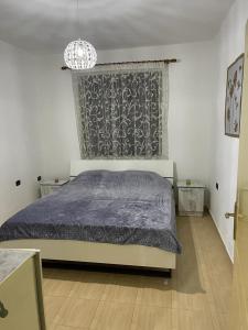 a bedroom with a bed and a chandelier at Dibra Home near City Center of Shkodra in Shkodër