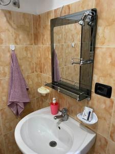 a bathroom with a sink and a mirror at Dibra Home near City Center of Shkodra in Shkodër