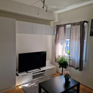 sala de estar con TV de pantalla plana y mesa en Spacious 1 bedroom apartment en Lorenskog