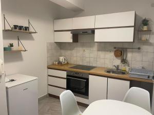a kitchen with white cabinets and a sink at Apartman Doris in Split