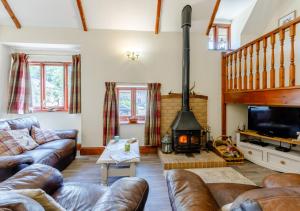 sala de estar con sofá y chimenea en Ash Cottage en Dulverton