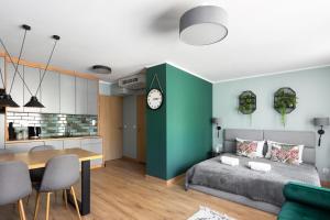 a bedroom with a bed and a table and a kitchen at Mary&Arte Apartments Grzegórzecka 15 in Krakow