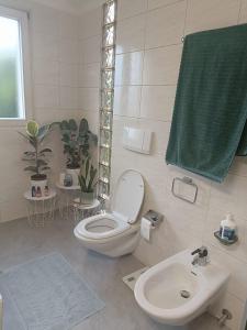 a white bathroom with a toilet and a sink at Casa al Sole in Paradiso