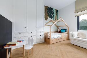 a childs bedroom with a crib and a table at Sielsko Tu - Warmiński Port #13 in Olsztyn +41 photos