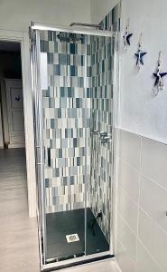 a bathroom with a shower with a tiled wall at Appartamento Tizzy in La Maddalena