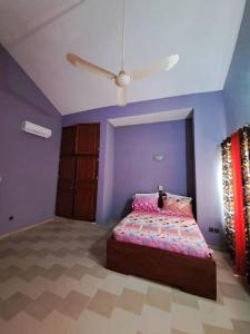 una camera con letto e ventilatore a soffitto di illémi Guest house ad Abomey-Calavi