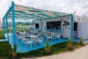 a restaurant with tables and chairs on a blue deck at Glamping By The Sea in Năvodari