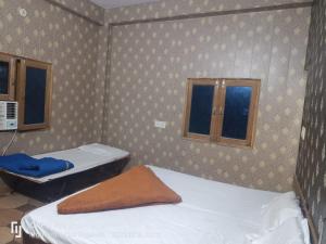 a small room with two beds and a window at Goroomgo Shree Anand Guest House Mathura in Mathura