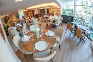 um restaurante com mesas e cadeiras num quarto em Castelmar Hotel em Florianópolis