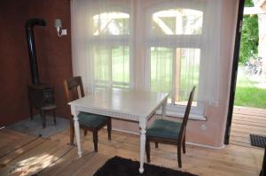 einen weißen Tisch und Stühle in einem Zimmer mit Herd in der Unterkunft Apartment Battin 44 Uckermark in Brüssow