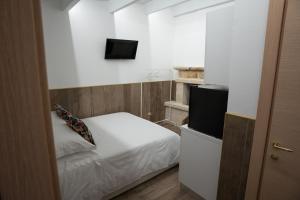 ein kleines Schlafzimmer mit einem Bett und einem TV in der Unterkunft Cala Baby Accommodation in Gravina in Puglia