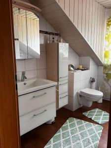 een badkamer met een wastafel en een toilet bij Ferienwohnung Weingarten 