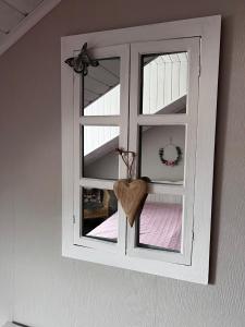 een raam met een hart in een kamer bij Ferienwohnung Weingarten 