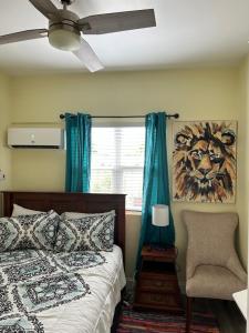 ein Schlafzimmer mit einem Bett, einem Stuhl und einem Fenster in der Unterkunft Lucia Bayview House in Glanvillia