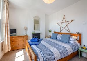 - une chambre avec un lit, une commode et une télévision dans l'établissement The Nook, à Beaumaris