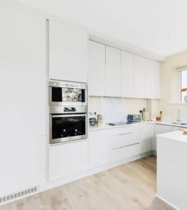 a white kitchen with white cabinets and appliances at Luxury Seaview Apartment in Dublin