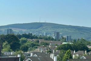 a city with houses and a hill in the background at Luxury Seaview Apartment in Dublin