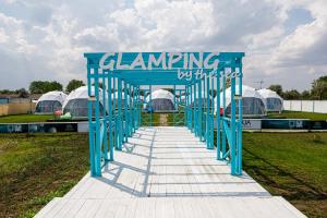 une arche bleue avec un groupe de tentes dans un champ dans l'établissement Glamping By The Sea, à Năvodari