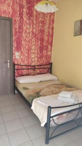 two beds in a room with a red curtain at Villa Marili in Paralia Katerinis