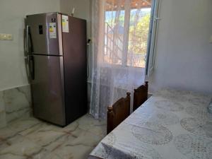 a kitchen with a stainless steel refrigerator and a table at Shamil House in Makhinjauri