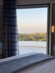 una camera da letto con una grande finestra che si affaccia su un patio di Olgas Luxury Villa, Corfu Greece a Evropoúloi