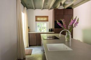 a kitchen with a sink and a counter top at Fantastisch familiehuis met grote tuin I Bosrijk in Lunteren