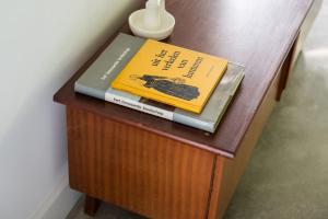 two books sitting on top of a wooden table at Fantastisch familiehuis met grote tuin I Bosrijk in Lunteren