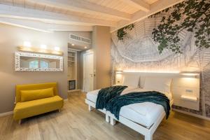 a bedroom with a bed and a yellow chair at Bianco Hotel in Primaluna