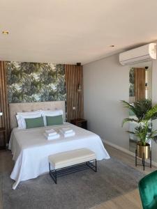 a bedroom with a large white bed with a table at Atlântico Azul in Funchal