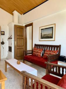 a living room with a red couch and a table at Κατοικία σε Συγκρότημα στην Ουρανούπολη in Ouranoupoli