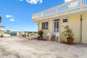 een huis met palmbomen ervoor bij Puntas Rincon Villa 301 with private rooftop terrace in Rincon