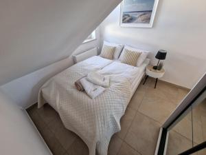 1 dormitorio con 1 cama con sábanas y almohadas blancas en Apartamenty Malaga, en Darłowo