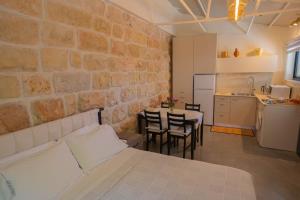 a room with a bed and a table and a kitchen at פרלה צימרים in ‘En Kerem