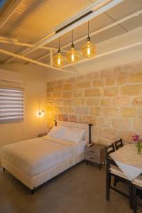 een slaapkamer met een bed en een bakstenen muur bij פרלה צימרים in Jeruzalem