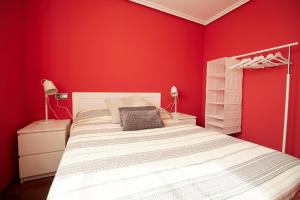 1 dormitorio rojo con 1 cama y 2 lámparas en CAMINODEHEROS, en Avilés
