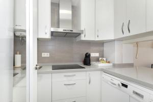 cocina blanca con armarios blancos y fogones en HI ROOM - Smart Apartments - HE 2, en Granada