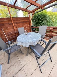 einen Tisch und vier Stühle auf einer Terrasse in der Unterkunft Ferienhaus Feldblick in Greifswald