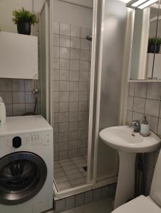 een badkamer met een wasmachine en een wastafel bij Two bedroom apartment close to city center in Jyväskylä