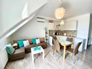 a living room with a couch and a table and a kitchen at Gallery Residence - Keszthely in Keszthely
