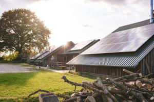 eine Gruppe Scheunen mit Sonnenkollektoren auf dem Dach in der Unterkunft DOMO CAMP - Nature Glamping Hof Viehbrook in Rendswühren